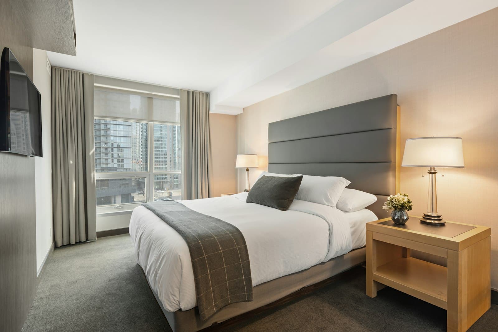 A made bed with white sheets, a duvet, and pillows.