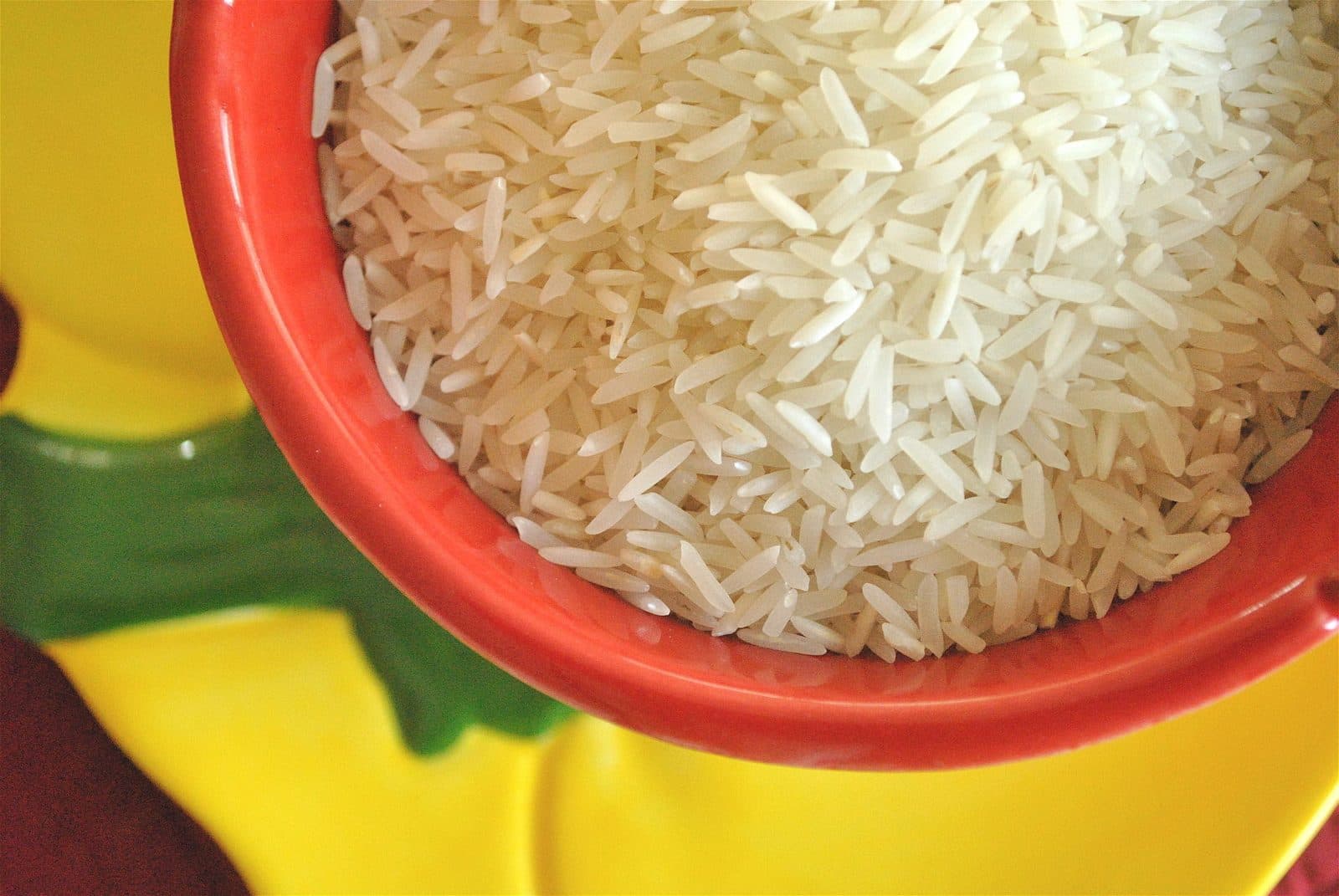 A bowl of long, slender uncooked basmati grains.